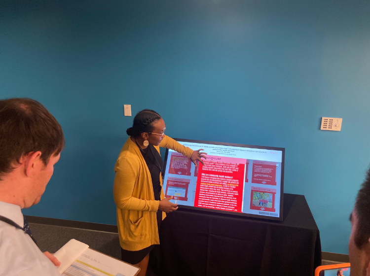 Person presenting an iPoster on a big screen at the V Scholar Summit 2022