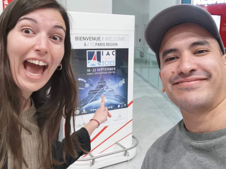 IAC - Space for all: A selfie of 2 people standing in front of a sign that says: 'Bienvenue a Paris' 'Welcome to Paris' with a poster for the IAC under it.