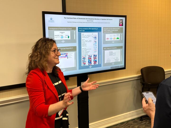 A person standing in-front of a touch screen with an iPoster displayed on it at the 2023 V Summit